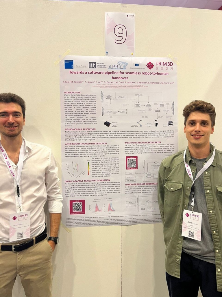 Mattia Penzotti and another researcher posing for a picture during the poster session, after the presentation of the papers